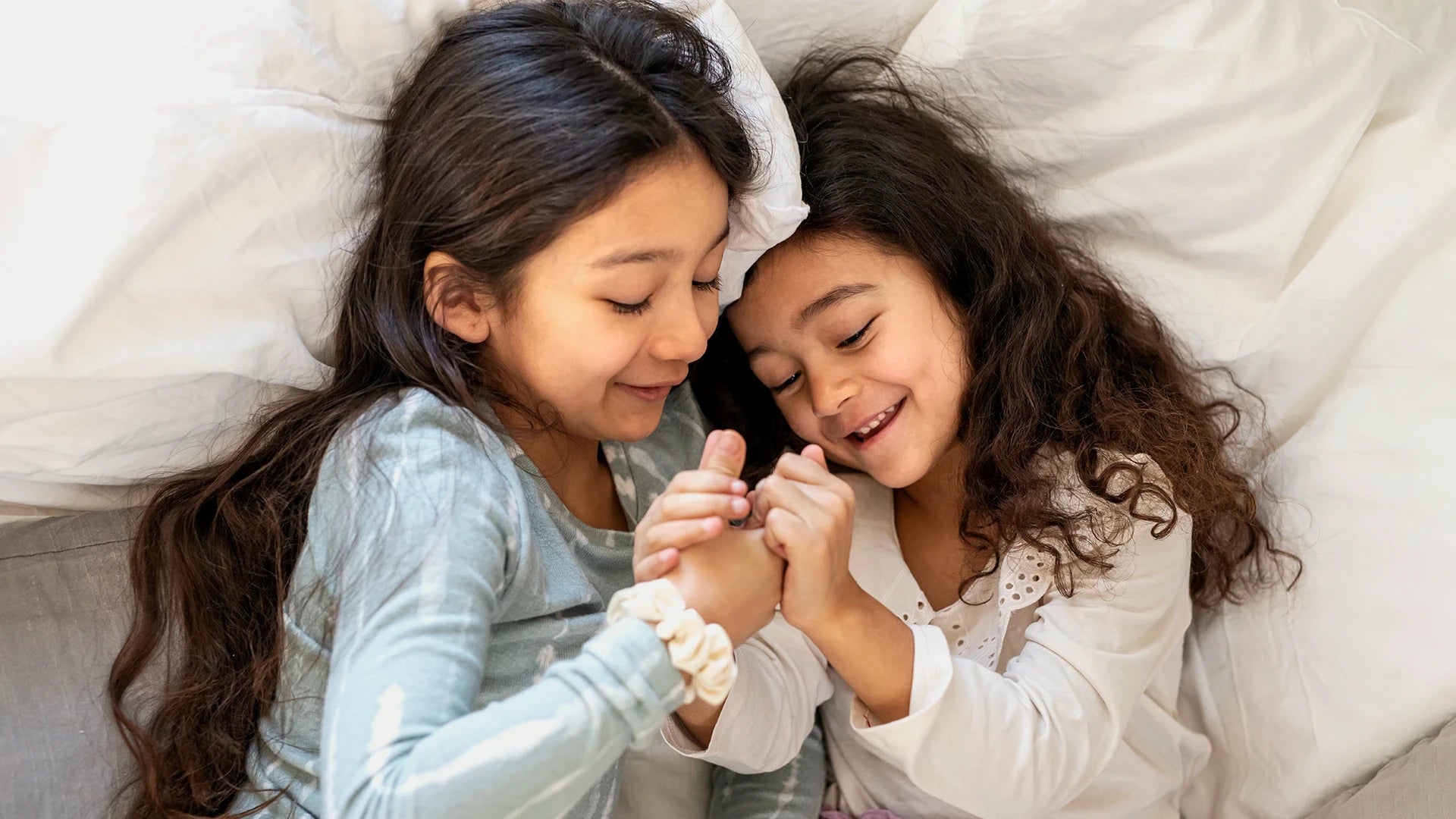 Smiling children playing in bed